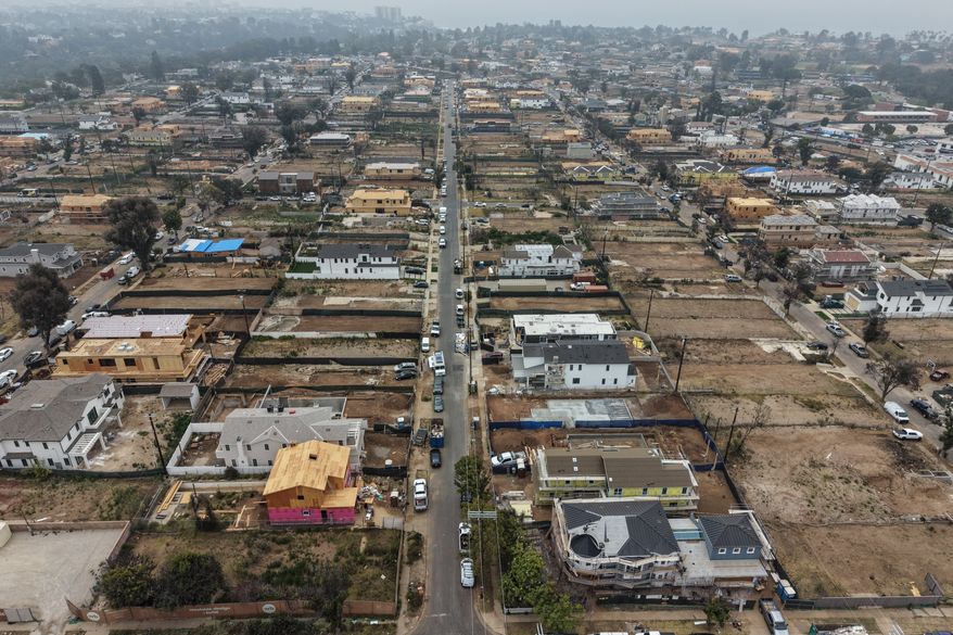 FILE - An aerial view shows homes under construction amid empty lots, June 4, 2026, more than a year after the Palisades Fire in the Pacific Palisades neighborhood of Los Angeles. (AP Photo/Jae C. Hong, File)