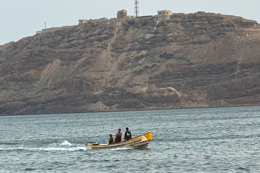 FILE - A boat motors under Al-Maashiq Presidential Palace, at top, in Aden, Yemen, Aug. 20, 2024. (AP Photo, File)