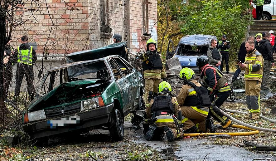 In this photo provided by the Ukrainian Emergency Service, emergency services personnel work in residential neiboorhud following a Russian air attack in Kyiv, Ukraine, Thursday, Oct. 15, 2026. (Ukrainian Emergency Service via AP)