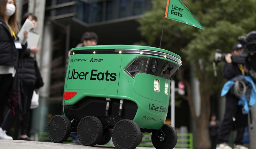 An Uber Eats food delivery robot moves on a pavement during its demonstration for media in Tokyo, Japan, Tuesday, March 5, 2024. Uber Eats Japan plans to launch the robot delivery service in a neighborhood in Tokyo, on Wednesday. (AP Photo/Shuji Kajiyama)