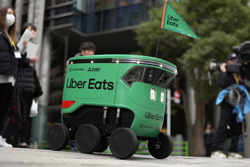 An Uber Eats food delivery robot moves on a pavement during its demonstration for media in Tokyo, Japan, Tuesday, March 5, 2024. Uber Eats Japan plans to launch the robot delivery service in a neighborhood in Tokyo, on Wednesday. (AP Photo/Shuji Kajiyama)
