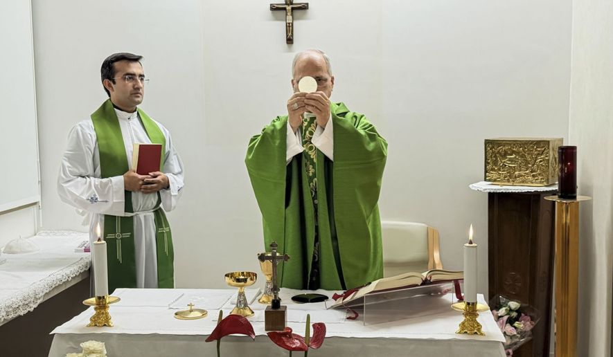 This picture, released by Vatican Media on Friday, Oct. 16, 2026, shows Pope Leo XIV, flanked by his personal secretary, Monsignor Edgard Iván Rimaycuna Inga, left, celebrating Mass at the Agostino Gemelli Polyclinic in Rome, where he is recovering after having cancer removed from his right lung. (Vatican Media via AP)