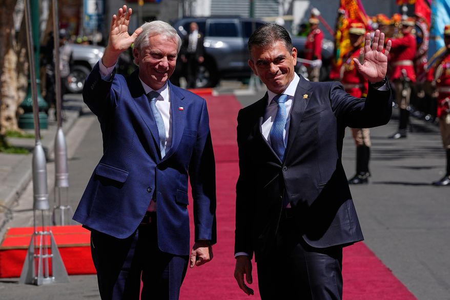 Bolivian President Rodrigo Paz, right, and Chile's President Jose Antonio Kast wave outside at the government palace in La Paz, Bolivia, Friday, Oct. 16, 2026. (AP Photo/Juan Karita)