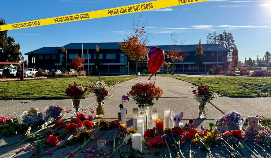 Flowers and candles are placed at a makeshift memorial at Silver Rail Elementary School in Bend, Ore., on Friday, Oct. 16, 2026, a day after a deadly shooting. (AP Photo/Haven Daley)