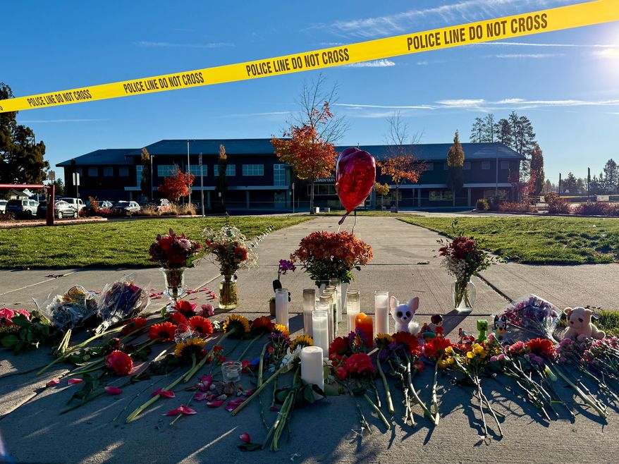 Flowers and candles are placed at a makeshift memorial at Silver Rail Elementary School in Bend, Ore., on Friday, Oct. 16, 2026, a day after a deadly shooting. (AP Photo/Haven Daley)