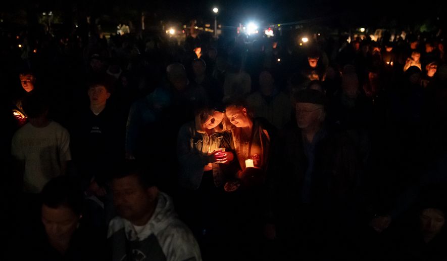 People mourn during a candlelight vigil at Drake Park following a deadly shooting at Silver Rail Elementary School in Bend, Ore. on Thursday, Oct. 15, 2026. (Eli Imadali/Oregon Public Broadcasting via AP)