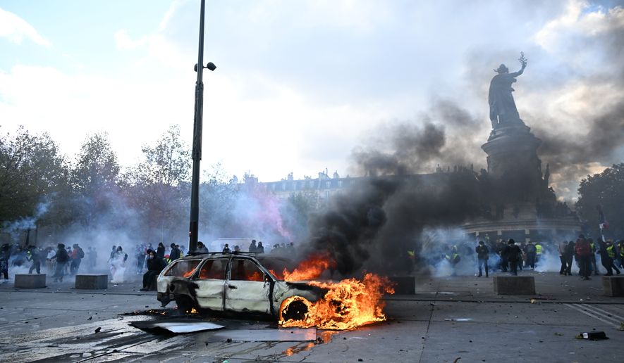 A car burns at Place de La Republique during a protest against rising living costs in Paris, Saturday, Oct. 17, 2026. (AP Photo/Emma Da Silva)