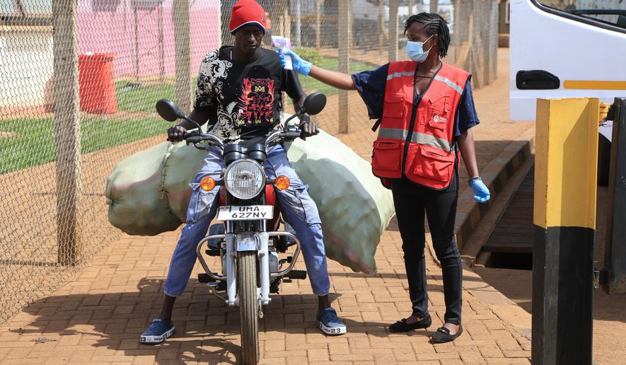 A Kenyan health worker checks the temperatures of travelers crossing from Uganda to Kenya as part of measures to contain the spread of Ebola virus, in Busia, Kenya, Thursday, Oct. 15, 2026. (AP Photo/Andrew Kasuku)