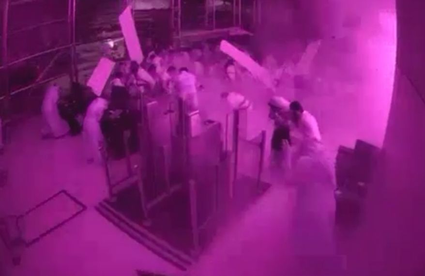 This image from CCTV video released by Saudi Arabia's Media Ministry shows passengers taking cover as flames and smoke fill part of King Khalid International Airport in Riyadh, Saudi Arabia, during what authorities described as a strike at the airport on Saturday, Oct. 10, 2026. (Saudi Media Ministry via AP)