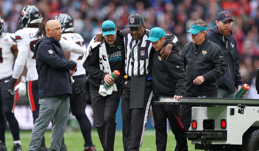 Umpire Larry Smith is assisted from the field after getting injured during an NFL football game between Houston Texans and Jacksonville Jaguars in London, Sunday, Oct. 18, 2026. (AP Photo/Ian Walton)