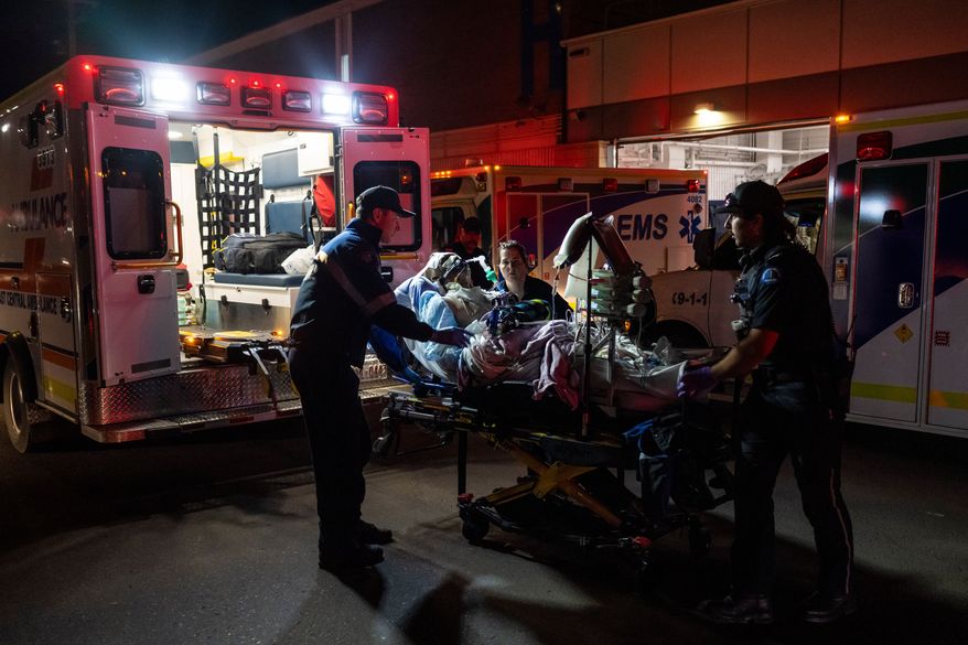 Paramedics load an injured person into an ambulance at the Wainwright Health center after a fire at Canadian Forces Base Wainwright, outside of Wainwright, Alberta Saturday, Oct. 17, 2026. (John Ulan/The Canadian Press via AP)