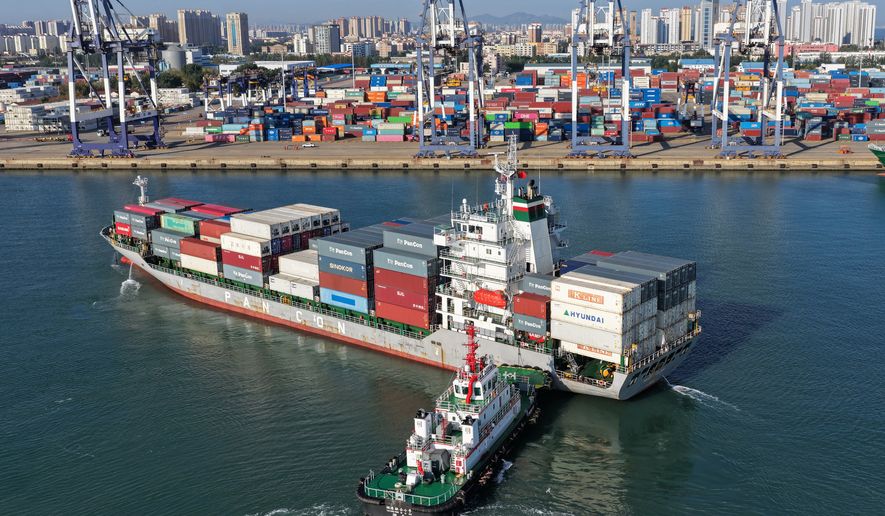 A tugboat pushes a container ship to a port in Yantai, eastern China's Shandong province on Oct. 14, 2026. (Chinatopix via AP)