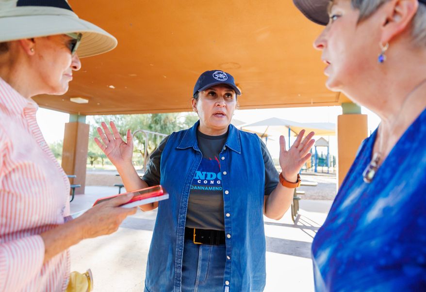 JoAnna Mendoza (D), an Arizona Congressional District 6 candidate, center, talks with campaign volunteers before a weekly neighborhood canvass, Thursday, Oct. 15, 2026, in Oro Valley, Ariz. (AP Photo/Mike Christy)