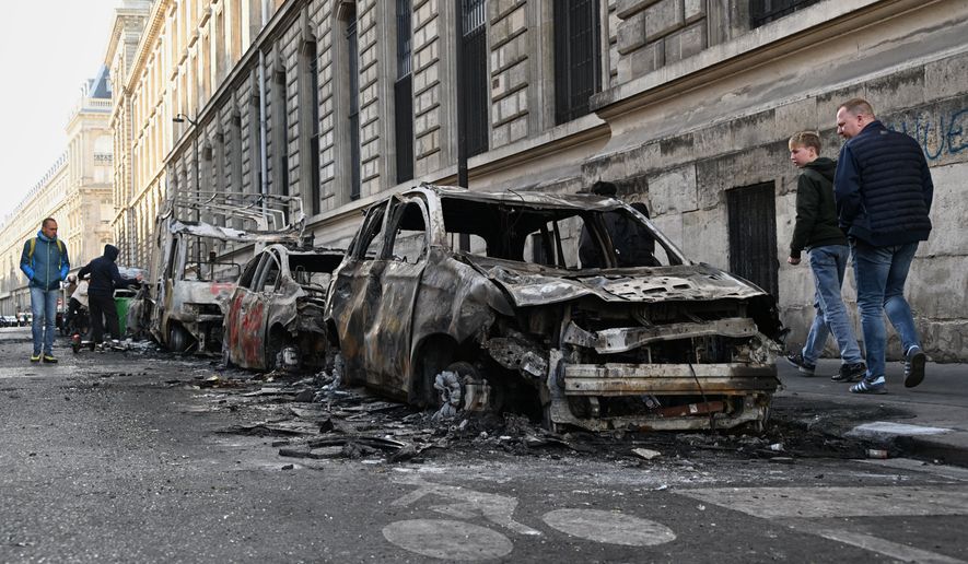 People look at charred cars the day after a demonstration against rising living costs, joining students' grievances, in Paris, Sunday, Oct. 18, 2026. (AP Photo/Emma Da Silva)