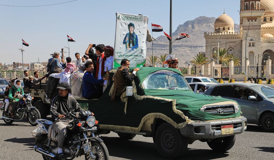 People ride in a pickup truck during a funeral procession for a Houthi officer in Sanaa, Yemen, Saturday, Oct. 17, 2026. The Arabic banner reads, "Martyr Mazen Abdallah." (AP Photo/Osamah Abdulrahman)