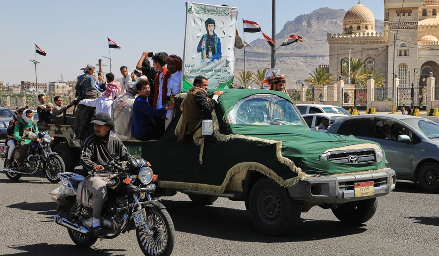 People ride in a pickup truck during a funeral procession for a Houthi officer in Sanaa, Yemen, Saturday, Oct. 17, 2026. The Arabic banner reads, "Martyr Mazen Abdallah." (AP Photo/Osamah Abdulrahman)