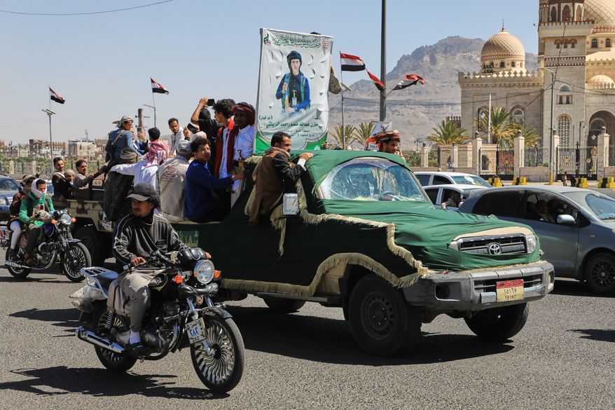 People ride in a pickup truck during a funeral procession for a Houthi officer in Sanaa, Yemen, Saturday, Oct. 17, 2026. The Arabic banner reads, "Martyr Mazen Abdallah." (AP Photo/Osamah Abdulrahman)