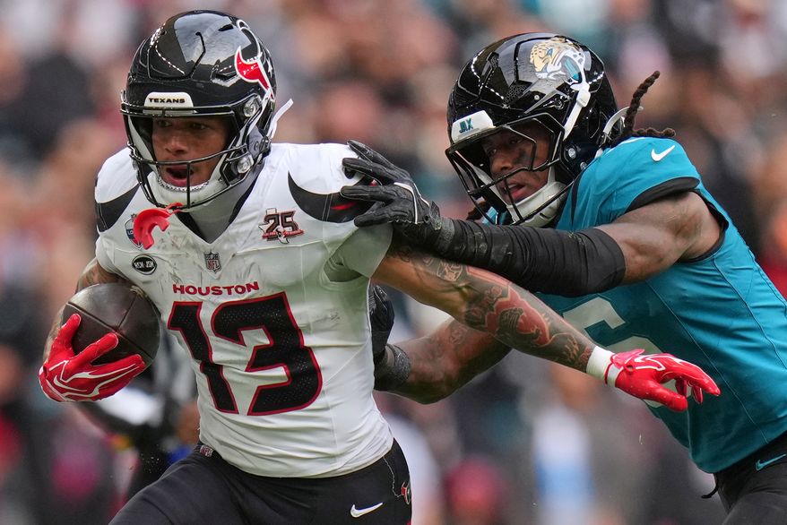 Houston Texans wide receiver Jaylin Noel (13) is challenged by Jacksonville Jaguars safety Antonio Johnson (6) during an NFL football game in London, Sunday, Oct. 18, 2026. (AP Photo/Kin Cheung)