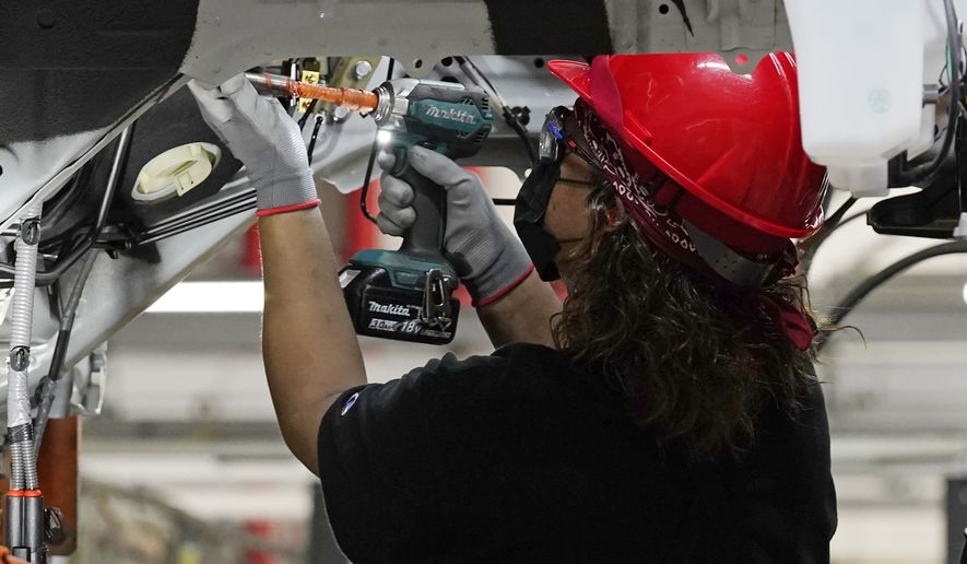A technician works on a Altima sedan at Nissan's Canton Vehicle Assembly Plant, Thursday, Feb. 17, 2022, in Canton, Miss. Company officials formally announced that the plant will become a center for electric vehicle manufacturing in the United States and will build two all-new electric models at the plant by 2025. (AP Photo/Rogelio V. Solis)