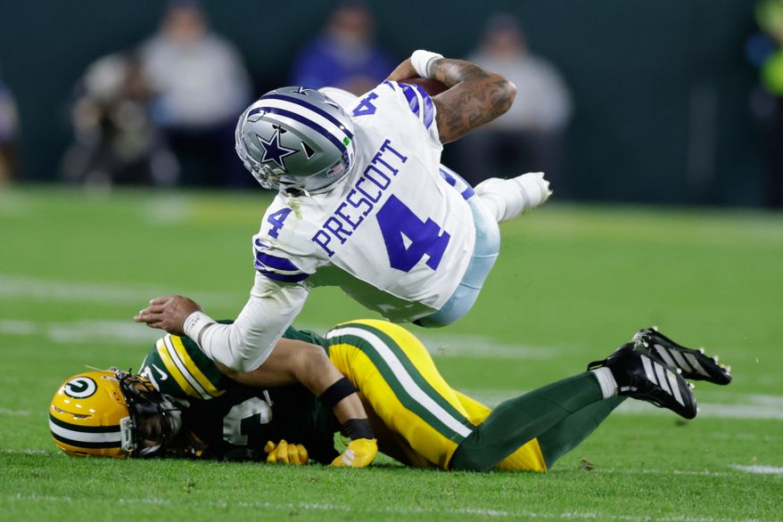 Green Bay Packers' Evan Williams stops Dallas Cowboys' Dak Prescott during the second half of an NFL football game in Green Bay, Wis., Sunday, Oct. 18, 2026. (AP Photo/Matt Ludtke)