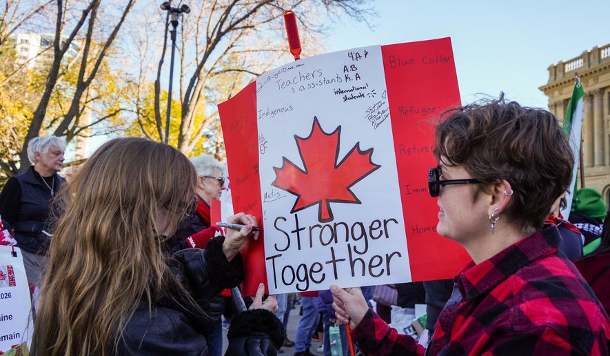 A supporter writes on a protest sign during a pro-Canada rally in Edmonton, Alberta, Sunday, Oct, 18, 2026. (Timon Johnson/The Canadian Press via AP)