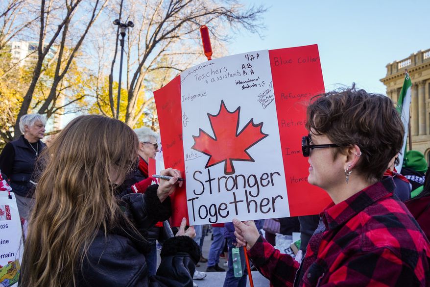 A supporter writes on a protest sign during a pro-Canada rally in Edmonton, Alberta, Sunday, Oct, 18, 2026. (Timon Johnson/The Canadian Press via AP)