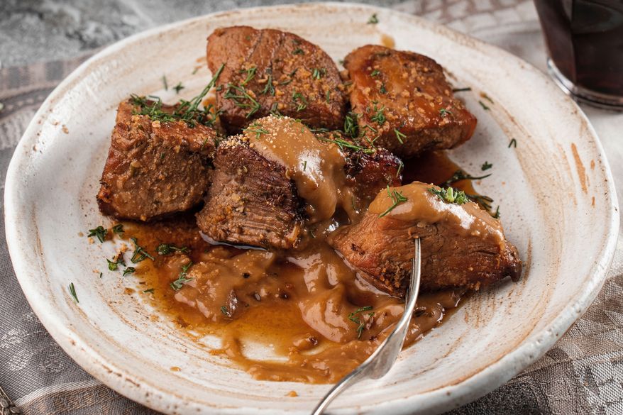 This image released by Voracious shows a recipe for beer-braised roast pork from the cookbook “The Authentic Ukrainian Kitchen” by Yevhen Klopotenko. (Dima Bahta/Voracious via AP)