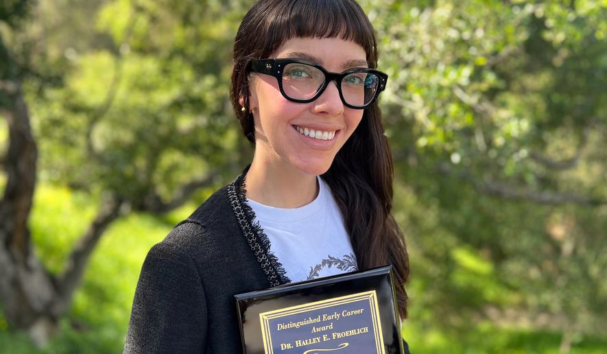 This photo taken with a smart phone and provided by Halley Froehlich shows Froehlich holding a U.S. Aquaculture Society award in Santa Barbara, Calif., on Feb. 27, 2026. (Halley Froehlich via AP)
