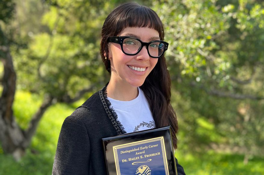 This photo taken with a smart phone and provided by Halley Froehlich shows Froehlich holding a U.S. Aquaculture Society award in Santa Barbara, Calif., on Feb. 27, 2026. (Halley Froehlich via AP)