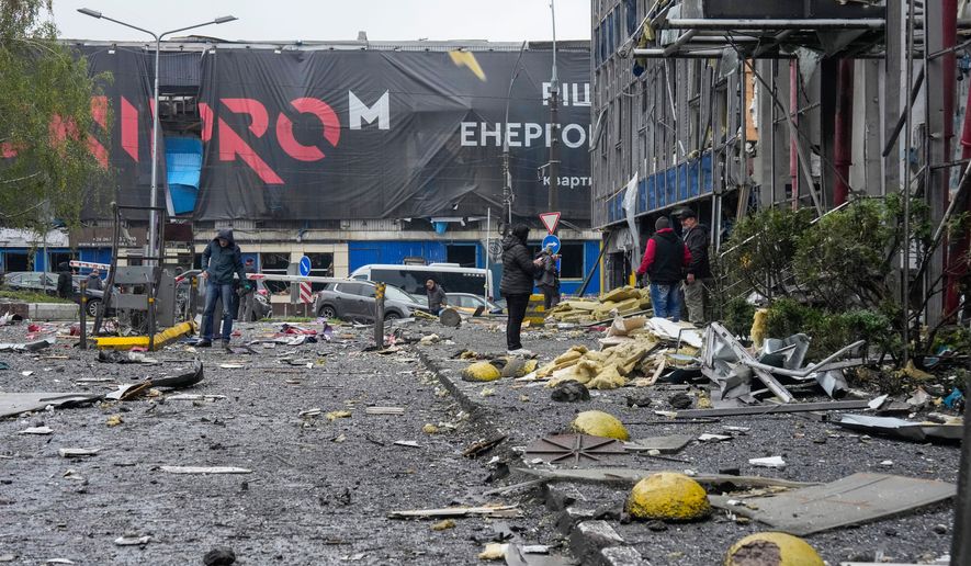 People look at damaged office center after a Russian missile attack in central Kyiv, Ukraine, Monday, Oct. 19, 2026. (AP Photo/Efrem Lukatsky)