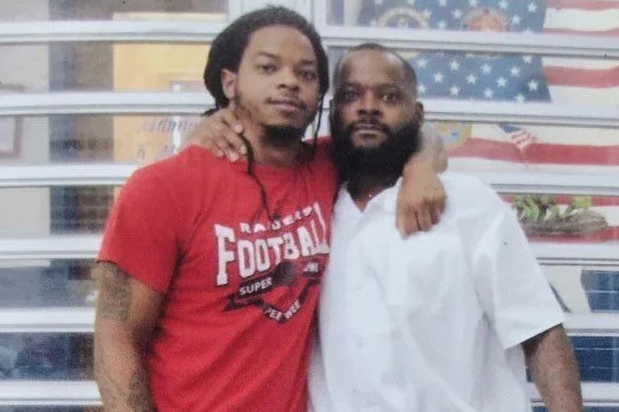 In this undated photo provided by the Johnson family on Tuesday, Oct. 20, 2026, Toforest Johnson, right, poses for a photo with his son, Robby Foster. (Johnson Family via AP)