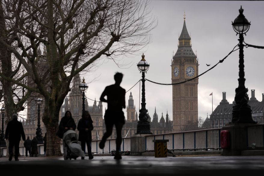 People walk on the banks of the Thames beside the Elizabeth Tower, known as Big Ben, and the Houses of Parliament in London, Wednesday, Feb. 11, 2026. (AP Photo/Kin Cheung, File)
