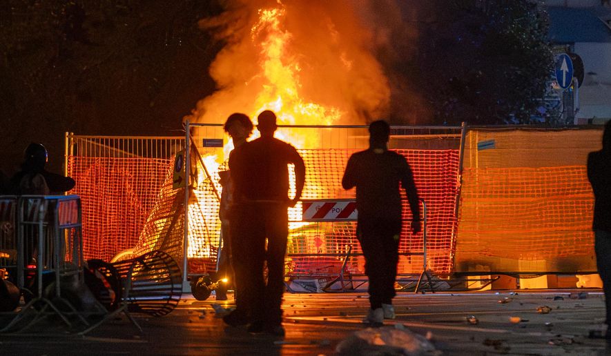 A fire burns following clashes between police and "Italia in Piazza" protesters in front of the Milan Cathedral in Milan, Italy, on Saturday, Oct. 17, 2026. (Stefano Porta/LaPresse via AP)