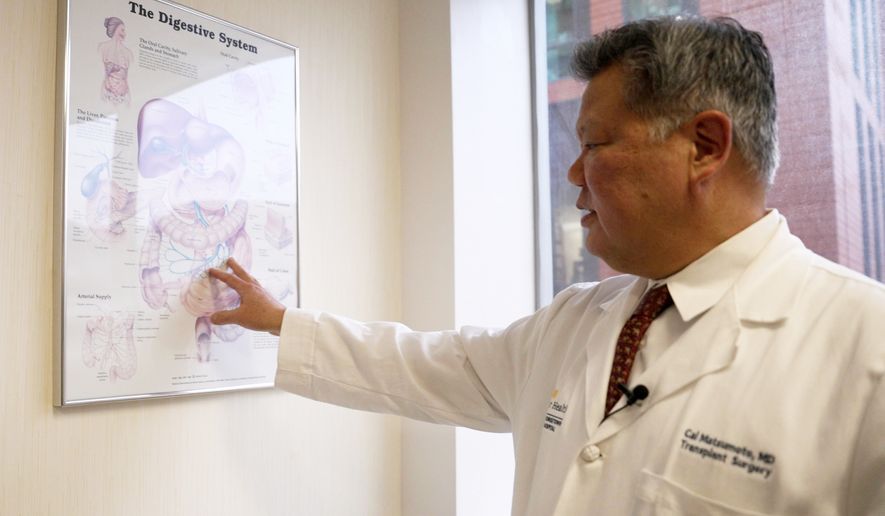 Dr. Cal Matsumoto, a MedStar Georgetown University Hospital transplant surgeon, gestures to a chart on the digestive system on March 4, 2026, in Washington. (AP Photo/Shelby Lum)