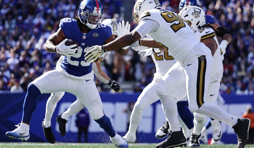 New York Giants running back Najee Harris (23) defends against New Orleans Saints linebacker Cameron Jordan (94) during the first half of an NFL football game in East Rutherford, N.J., Sunday, Oct. 18, 2026. (AP Photo/Adam Hunger)