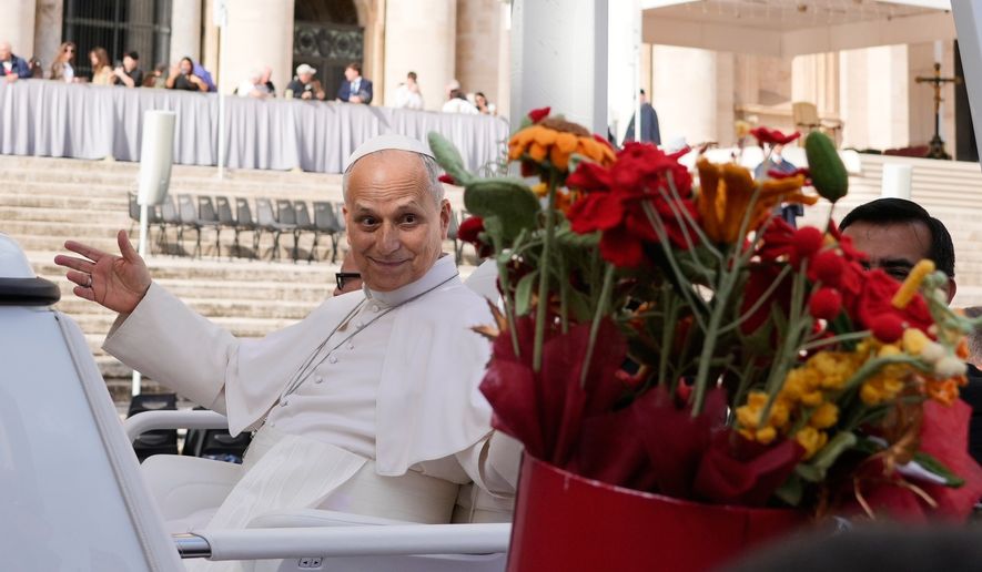 Pope Leo XIV is presented with flowers as he leaves at the end of the general audience in St. Peter's Square at The Vatican, Wednesday, Oct. 21, 2026. (AP Photo/Gregorio Borgia)