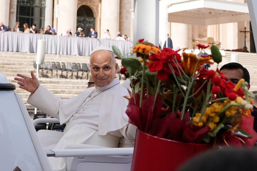Pope Leo XIV is presented with flowers as he leaves at the end of the general audience in St. Peter's Square at The Vatican, Wednesday, Oct. 21, 2026. (AP Photo/Gregorio Borgia)