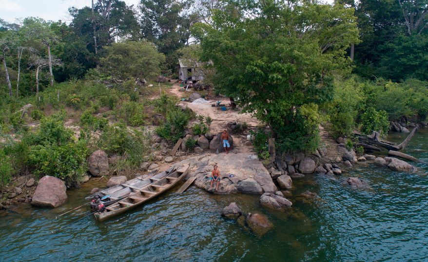 A fisher sits outside his home on the banks of the Xingu River, near the Belo Monte hydroelectric dam in Altamira, Para state, Brazil, Sept. 6, 2019. (AP Photo/Andre Penner, File)