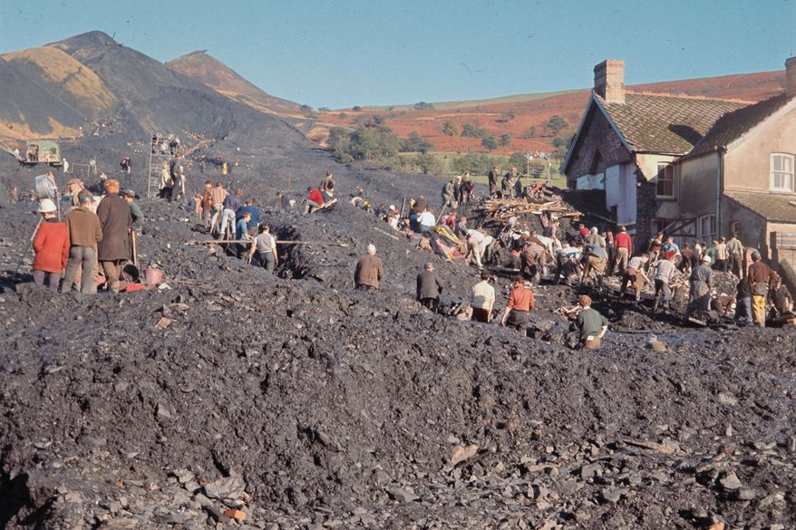 Rescue workers toil in the huge pile of rubble, after the collapse of a slag tip, in Aberfan, Wales, Oct. 22, 1966. (AP Photo, File)