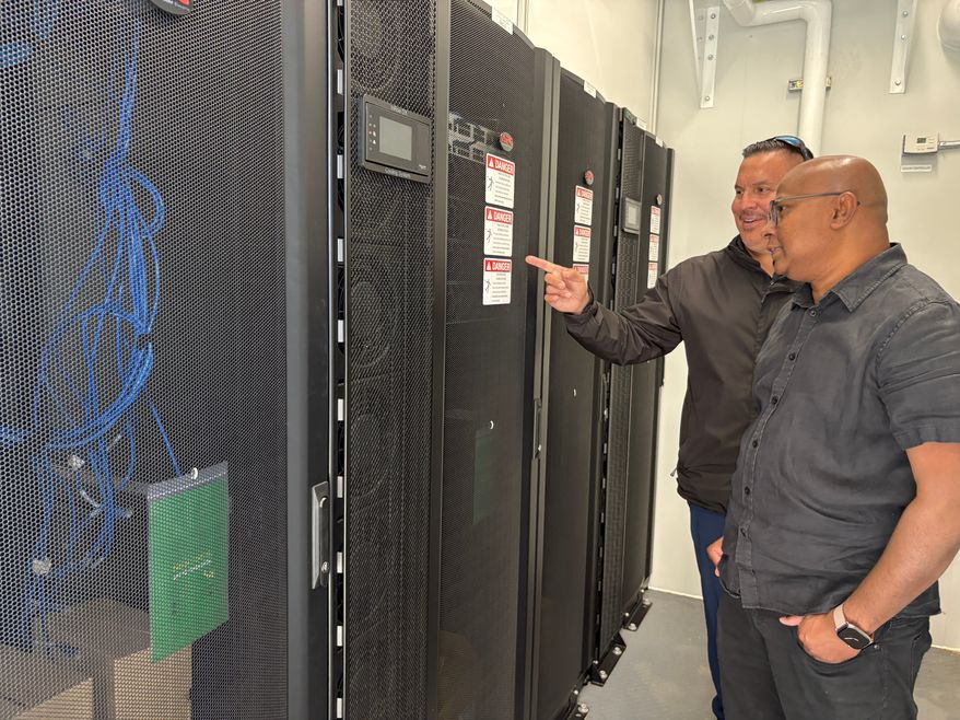 Wiikwemkoong's Chief Technology Officer Michael McCormick, right, and a worker inspect the community's data center in Wiikwemkoong, Ontario, Canada, July 22, 2026. (AP Photo/Kelvin Chan)