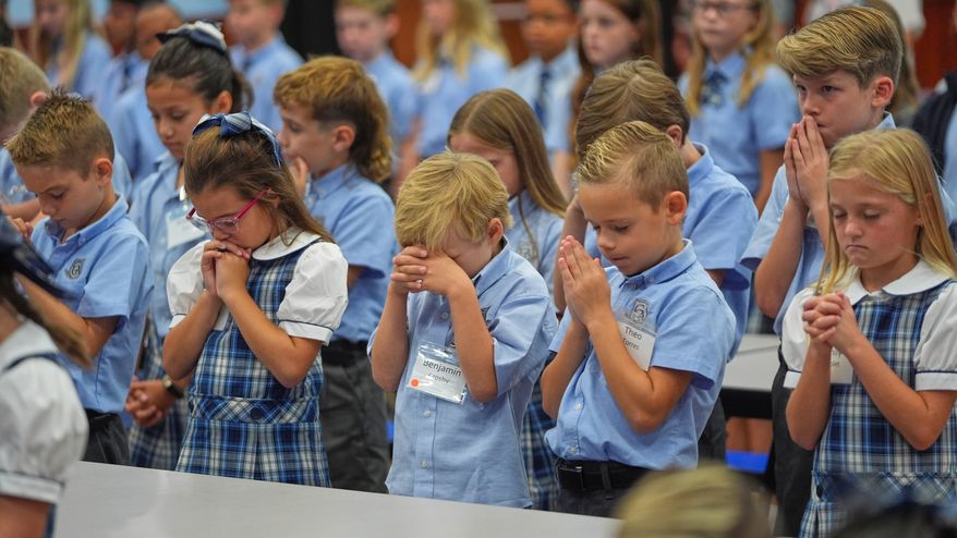 Children at Covenant Christian Academy pray during chapel at the private school in Colleyville, Texas, Wednesday, Aug. 12, 2026. (AP Photo/LM Otero)