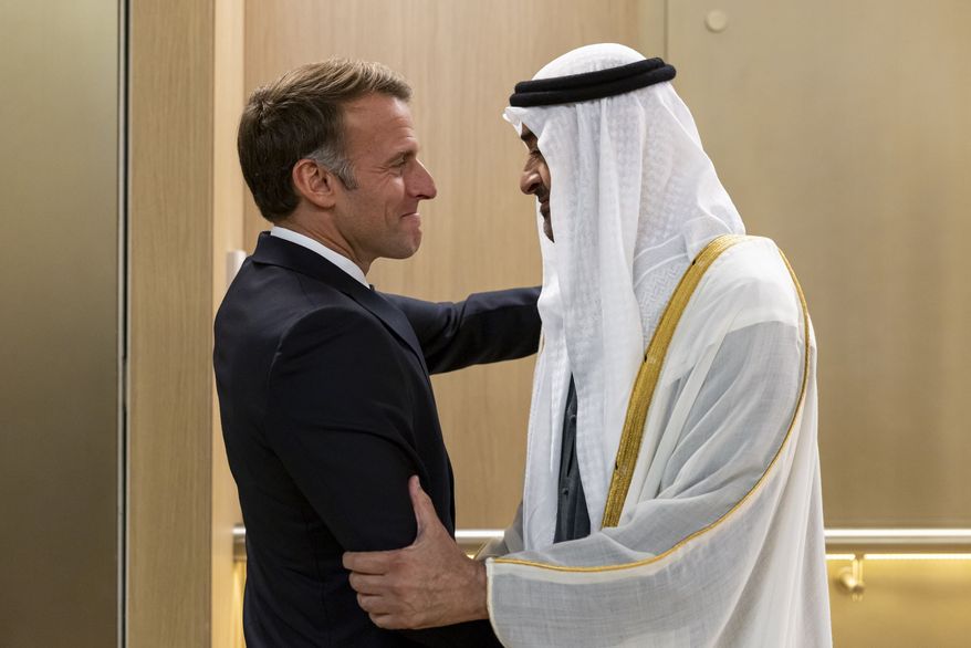 In this photograph released by the state-run WAM news agency, United Arab Emirates President Sheikh Mohammed bin Zayed Al Nahyan, right, greets French President Emmanuel Macron upon his arrival in Abu Dhabi, United Arab Emirates, Monday, Oct. 19, 2026. (WAM via AP)