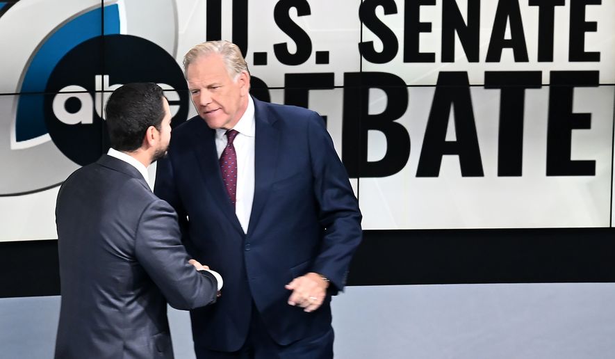 U.S. Senate candidates Democrat Abdul El-Sayed, left, and Republican Mike Rogers shake hands before the debate on Wednesday, Oct. 21, 2026 at WXYZ Channel 7 in Southfield, Mich. (Robin Buckson/Detroit News via AP, Pool)