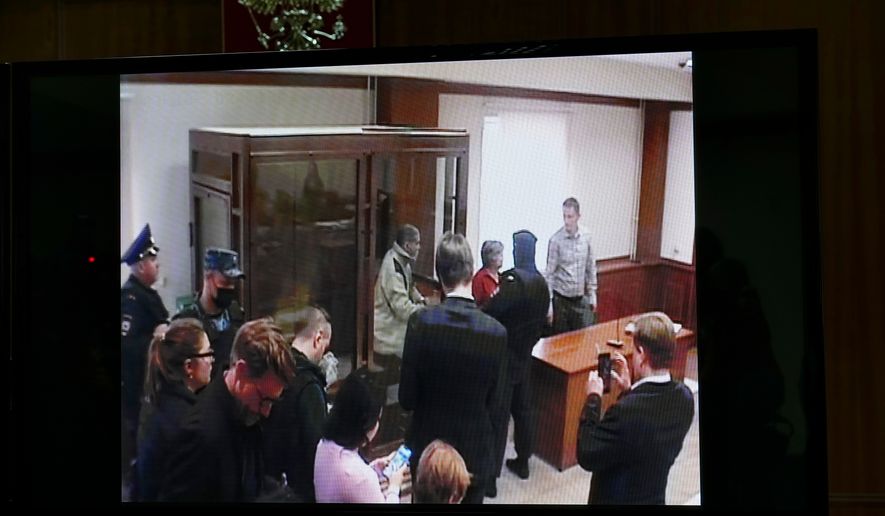 Stephen Hubbard, a U.S. citizen accused of fighting as a mercenary in Ukraine against Russia, appears on a video link as he stands in a glass cage during a court session in the Moscow City court in Moscow, Russia, Monday, Oct. 7, 2024. (AP Photo/Alexander Zemlianichenko, File)