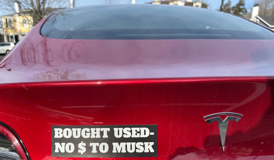 FILE - A Tesla vehicle displays a sticker referring to the car's purchase on Sunday, Dec. 15, 2024, in Concord, Mass. (AP Photo/Peter Morgan, File)
