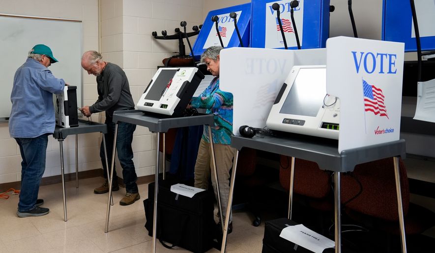 Poll workers set up ballot-marking machines at an early in-person voting site at Asheville-Buncombe Technical Community College, Oct. 16, 2024, in Marshall, N.C. (AP Photo/Stephanie Scarbrough, File)
