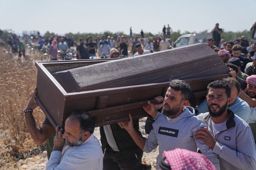 Mourners carry the coffin of Muath Salama al-Baeer, a young man with a disability who state media said was killed during an early morning Israeli military incursion, during his funeral in Jamla, in the Yarmouk Basin area of western Daraa province, Syria, Thursday, Oct. 22, 2026. (AP Photo/Ghaith Alsayed)
