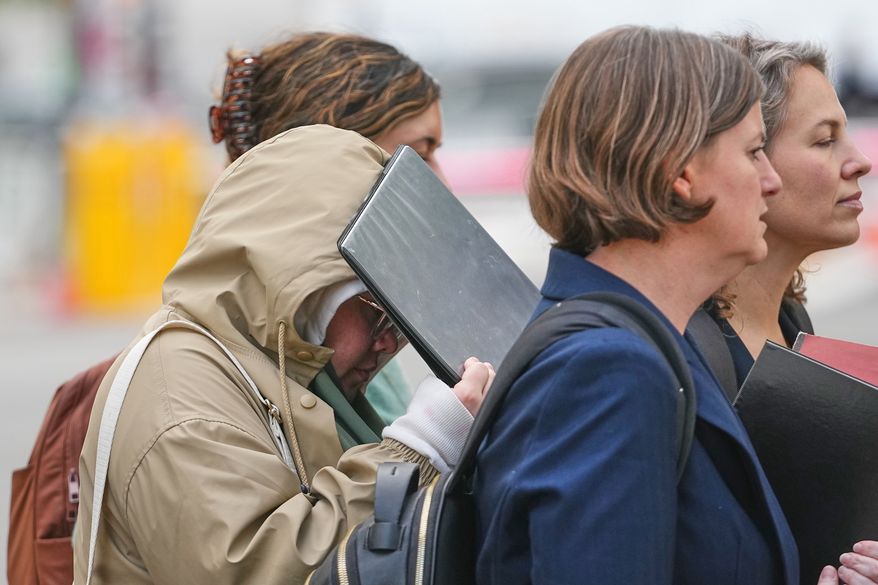 Halima Salman shields her face as she leaves federal court in the Brooklyn borough of New York on Wednesday, Oct. 21, 2026.” (AP Photo/Frank Franklin II)