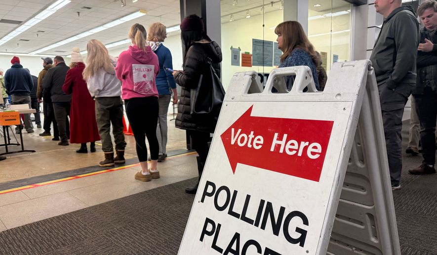 This photo taken with a smart phone, voters stand in line at an early voting location in a mall in Anchorage, Alaska, on Wednesday, Oct. 21, 2026. (AP Photo/Haven Daley)