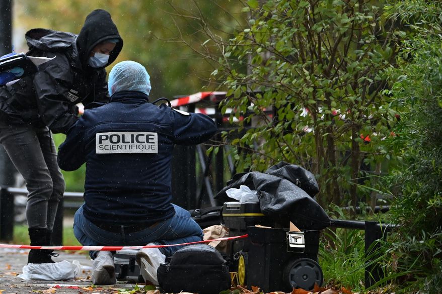 Forensic investigators search for evidence after a shooting in Trappes, outside Paris, Friday, Oct. 23, 2026. (AP Photo/Emma Da Silva)